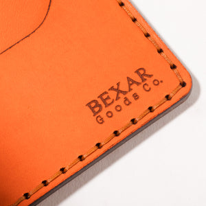 closeup view of laser engraved Bexar Goods on Orange four pocket bifold wallet